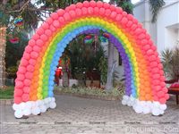 Rainbow balloon arch entrance to a theme birthday party made of 7 separate arches