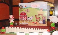 A Barnyard scene setter with a wooden fence for the stage decor for a little girls 2nd birthday party. The scene has all the elements of a farm - a barn, Cow, Horse, a Farmer, Pig, Sheep, duck and ducklings and the farm dog. 