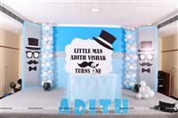 Stage setup includes a main backdrop, two side wings on either side, a tutu cover cake table with a center piece and the baby name alphabets cutouts.